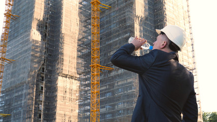 Portrait of a successful young handsome engineer, architect, builder, businessman, wearing a white...