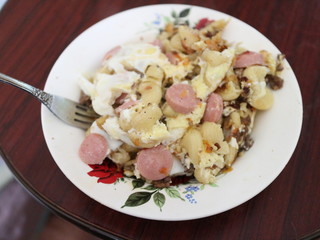 Fried eggs, sausages, potatoes in a plate