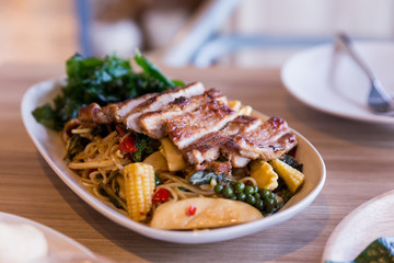 Drunken noodles: Spicy fried egg noodle with basil and pepper served with grilled pork.