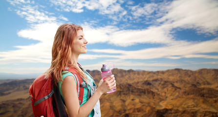 adventure, travel, tourism, hike and people concept - smiling young woman with backpack and bottle...