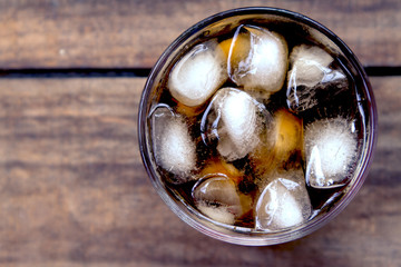 Topview a glass of cola with ice on the table.