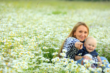 Matka z córką bawią się na łące pełnej kwiatów.
