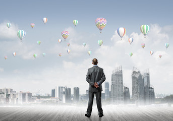 Motivation and inspiration concept with modern cityscape and businessman observing it