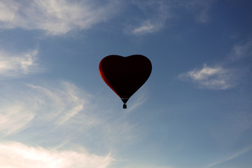 Fototapeta premium Red hot air balloon in the shape of a heart fly in sky. Love, honeymoon and romantic travel concept
