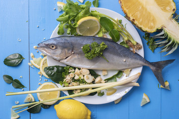 Fish food with ingredient spices on blue table