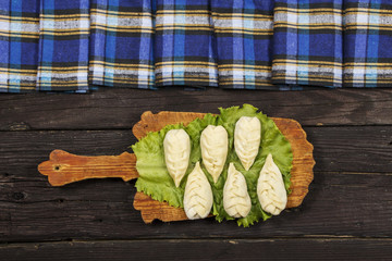 Vegetable salad with fresh vegetables and arugula on a wooden table. Salad with green fresh vegetables in a glass bowl. Vegetarian food salad. The concept of a healthy diet