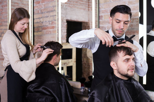 Barber making haircutting for male client