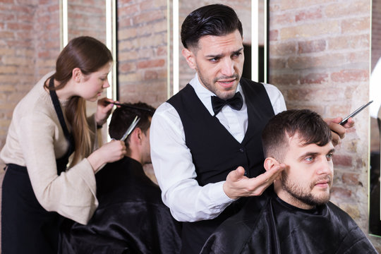 Hairdresser discussing preferences with male client