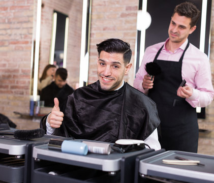 Delighted male client after haircut in salon
