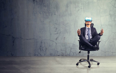 Businessman sitting in chair  wearing virtual reality glasses. Empty space for text or draw