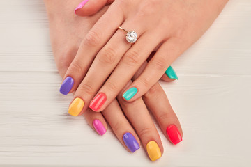 Ring with diamond on manicured hands. Hands of young woman with beautiful manicure and engagement ring. Female beauty and jewelry.
