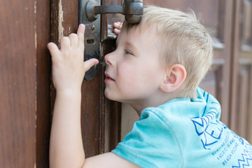 the child peeps through the keyhole.
