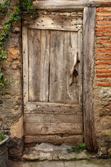 Vieille porte médiévale en bois dans un mur de brique et béton