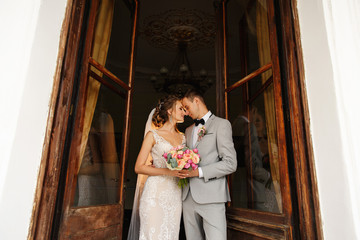 Wedding couple in love at wedding day. Beautiful bride and groom with wedding bouquet embracing...