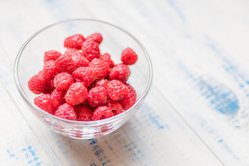 Raspberries in a glass plate.