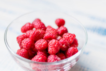 Raspberries in a glass plate.