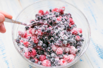 Fresh berries with sugar. Black currant and raspberries mixed for dessert.