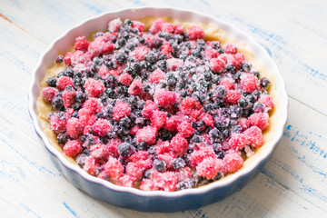 Preparation of a pie with fresh berries-raspberry and black currant.