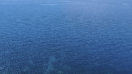  Aerial view of the blue waters of the Mediterranean Sea and specifically of the Tyrrhenian Sea. Sunlight is reflected on the surface of the water.