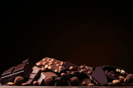 Chocolate pieces with nuts on wooden table