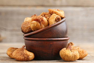 Dried figs in bowl on grey wooden table