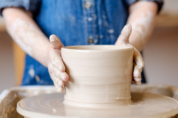 Fototapeta na wymiar pottery workshop. handmade craft. child artisan forming and shaping clay on potter wheel
