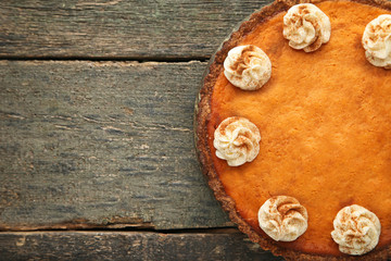 Fototapeta na wymiar Pumpkin tart with whipped cream on wooden table