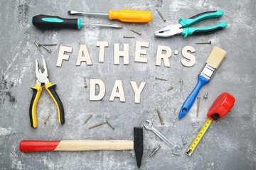 Inscription Fathers Day with different tools on wooden table