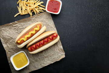 Hot dogs with mustard and ketchup on wooden table