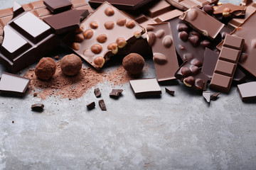 Chocolate pieces with nuts and candy balls on wooden table