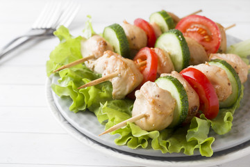 Traditional Turkey chicken kebab meat with tomatoes, cucumber and fresh herbs on a plate.