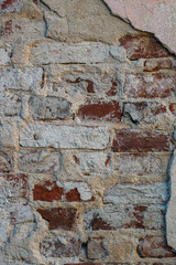 Aged brick wall with cracked plaster