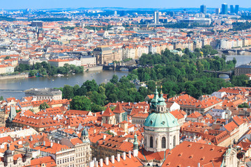 Fototapeta premium Beautiful and ancient city of Europe - Prague, Czech Republic. View of the city from the observation deck. Small houses and the river Vltava. Charles Bridge and temples.