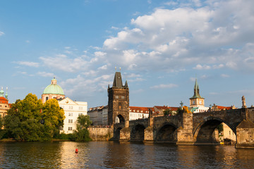 Beautiful and ancient city of Europe - Prague, Czech Republic. View of the city from the observation deck. Small houses and the river Vltava. Charles Bridge and temples.