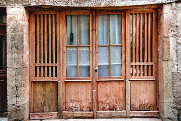 Vieille porte en bois avec fenêtre en verre dans un mur de pierre 