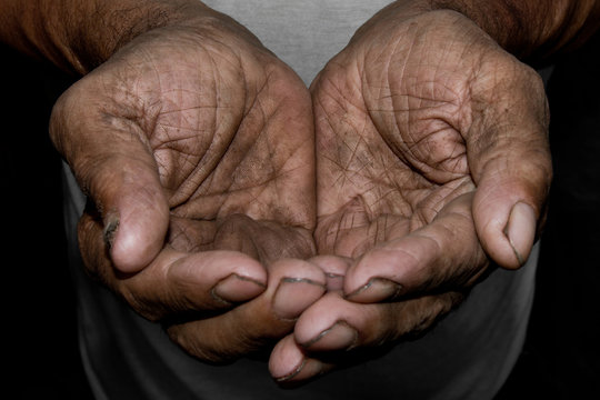 The poor old man's hands beg you for help. The concept of hunger or poverty. Selective focus.