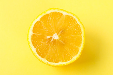 Top view of a one orange fruit slice on bright background in pastel color.