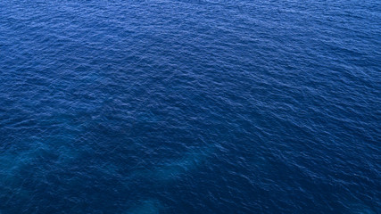 Fototapeta na wymiar Aerial view of the blue waters of the Mediterranean Sea and specifically of the Tyrrhenian Sea. Sunlight is reflected on the surface of the water.