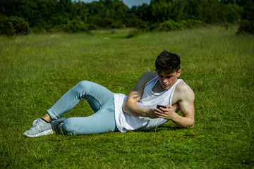 A young adult male sitting outside on a summer's day