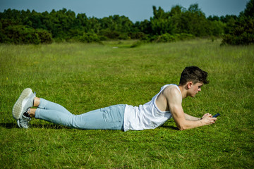 A young adult male sitting outside on a summer's day