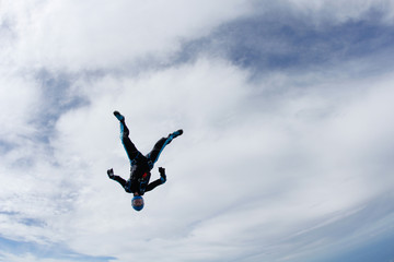 Fototapeta na wymiar Freefly skydiving. Girl is falling is a headdown position.