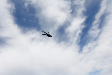 Parachutist is flying in the sky.