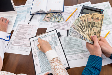 Obraz premium Counting taxes while filling 1040 tax form