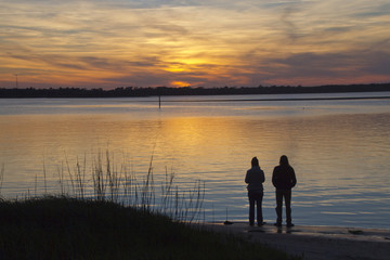 Couple Watches a Beautiful Sunset Over the Water Together