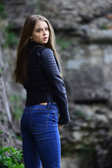 Naklejka na ściany i meble Summer or spring fashion and beauty. girl in casual clothes outdoor. look of girl near stony wall. Sexy woman with long hair at stone. sensual model with makeup after hairdresser.