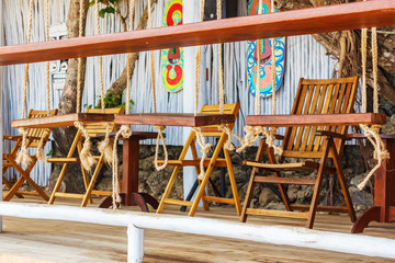 Fototapeta na wymiar interior cafe on the beach where the chairs are made in the form of a swingм
