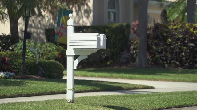 White US mailbox with a red flag in a suburban neighborhood - Florida, United States