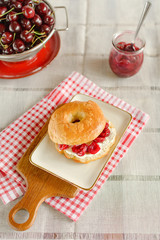 Ein selbst gebackener Bagel mit Frischkäse und Kirschmarmelade