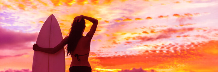 Hawaii surf summer vacation lifestyle. Silhouette of surfer woman at sunset with surfboard on beach. Banner panorama.