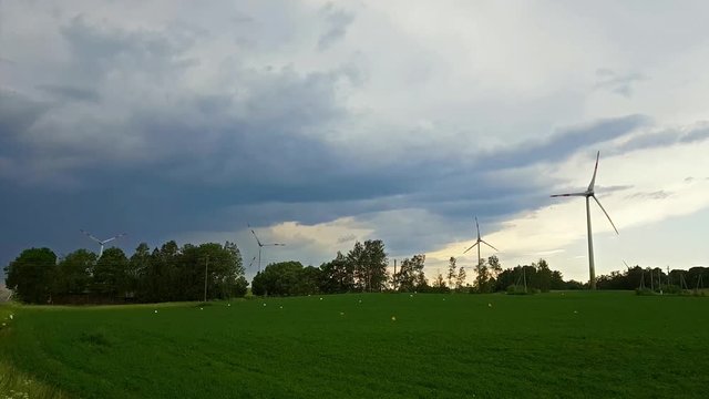 Windmills rotate blades over arable fields and farmland. Electric wind generators produce environmentally clean electricity using wind power. Taurage district, Lithuania, European Union
